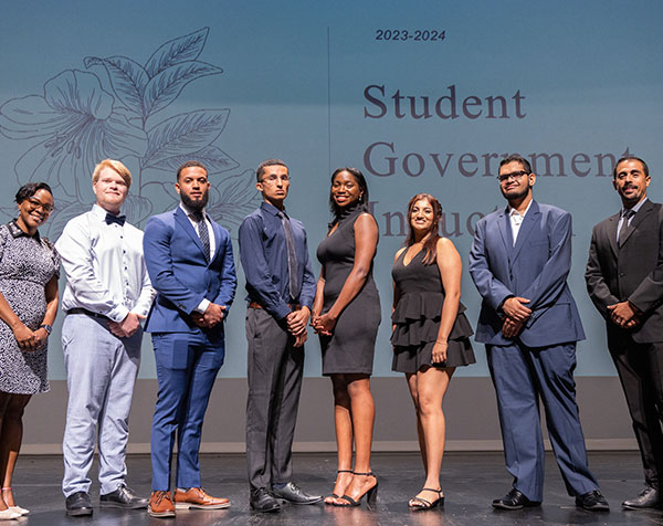 Eight Student Government Members On Stage Posing for a Group Photo